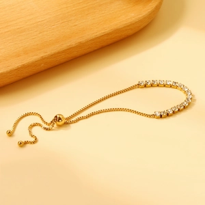 Bracelet doré réglable élégant avec des zircons brillants sur un fond aux tons doux