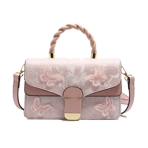 Sac à main rose avec broderies papillons 3D, textures florales et poignée torsadée