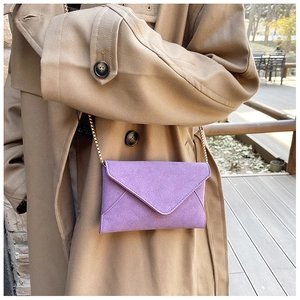 Detail of purple frosted envelope crossbody bag with a delicate gold chain strap