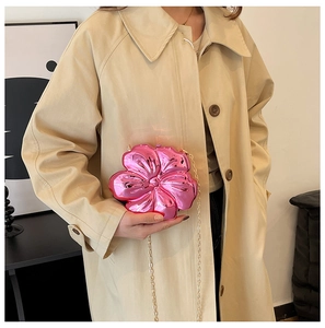 Close-up of a mini bright pink metallic flower petal bag with a gold chain strap