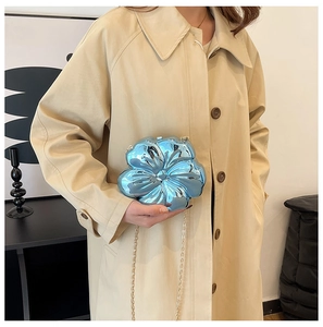 Detailed shot of light blue metallic flower mini bag with elegant gold chain strap
