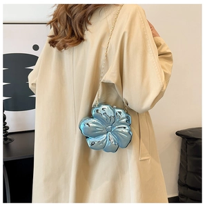 Close-up of mini light blue flower-shaped crossbody bag with metallic mirror finish and chain
