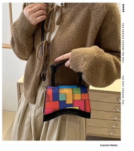 Détail du sac bandoulière à motif géométrique coloré avec base incurvée sur modèle