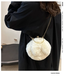 Vue détaillée du sac rond en fausse fourrure blanche avec chaîne dorée et fermoir boule