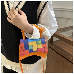 Gros plan sur le motif géométrique color-block d'un sac à main élégant en forme de sablier