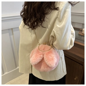 Détail du sac à main rose en peluche avec oreilles de lapin et chaîne dorée sur mannequin