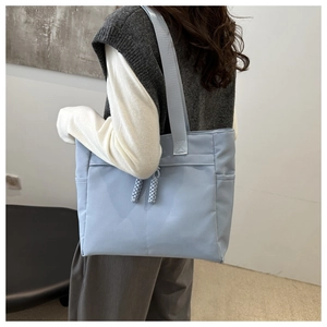 Side view of a light blue large capacity nylon tote bag shown on a model for daily commute