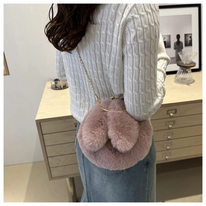 Détail du sac à bandoulière en peluche rose avec oreilles de lapin et chaîne dorée chic