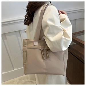 Détail d'un sac cabas beige en toile avec tirette de fermeture tissée et bandoulière en nylon