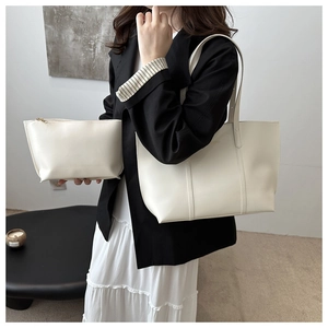 Detail view of white cream tote bag set with matching zipper pouch in minimalist room