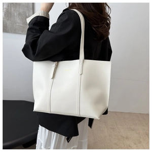Lifestyle shot of a white large leather tote bag with double straps on a model