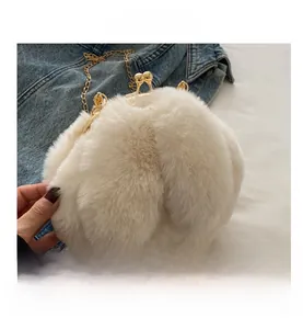 Détail de la texture en peluche blanc cassé avec fermoir boule doré et bandoulière chaîne