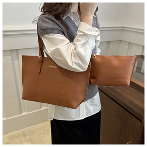 Close-up of brown faux leather tote and matching zipper pouch with gold text