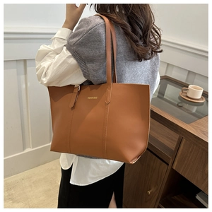 Close-up of caramel PU leather tote bag with Fashion & Bags gold lettering detail