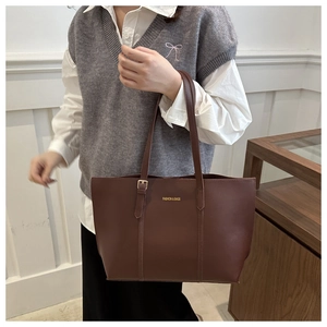 Detail showing the adjustable gold buckle and fine stitching on a dark brown tote bag