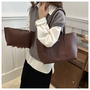 Close-up of a dark brown vintage tote bag set with a matching pouch and fine texture