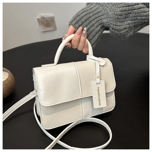 Vue détaillée du sac carré en cuir PU crème avec rabat magnétique et étiquette