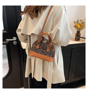 Close-up of leopard print shell bag worn with a cream trench coat for winter style