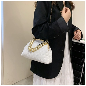 Détail du sac plissé blanc avec chaîne épaisse dorée et bandoulière en or