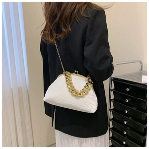 Détail du sac plissé blanc avec grosse chaîne dorée porté par un mannequin