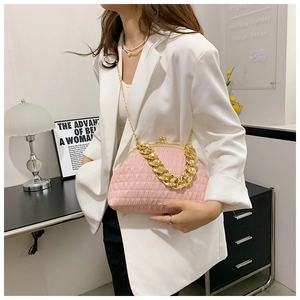 Detail of pink pleated shell handbag with chunky metal chain shown on white blazer