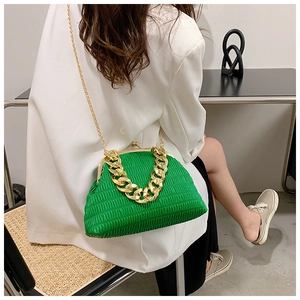 Détail du sac plissé vert vif avec grosse chaîne dorée et style de costume blanc chic