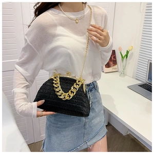 Detail of black pleated shell bag featuring chunky gold chain and vintage metal clasp
