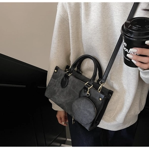Detail of dark grey suede tote bag with round coin purse and gold stud hardware