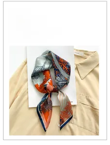 Close-up of printed silk square scarf in orange and navy blue on a fashion magazine