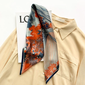 Detailed flat lay of silk square scarf showing nature prints and twill texture