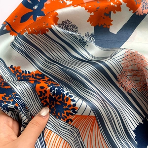 Detailed macro view of high-gloss silk square scarf with vibrant leaf and tree print