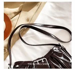Detail showing high-shine dark brown patent leather and silver metal rivet buckle