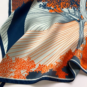 Detail of silk square scarf featuring artistic landscape print and fine rolled edges