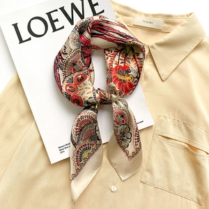 Fashionable silk square scarf with floral bird print on cream shirt background