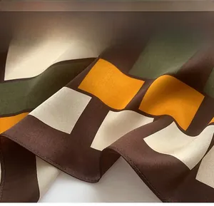 Detail of silk scarf showing precise hemmed edges and geometric color block pattern