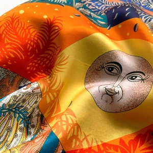 Detailed close-up of vibrant sun and floral print on high-quality silk square scarf
