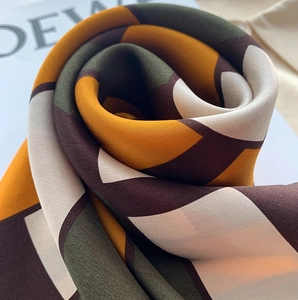 Detail of silk scarf with geometric color blocks in forest green and ginger yellow