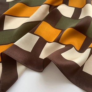 Close-up of vintage geometric pattern silk scarf showing smooth texture and drapes