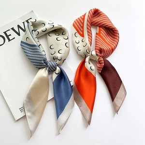 Detail of silk square scarf with crescent moon print and satin finish on a white lookbook