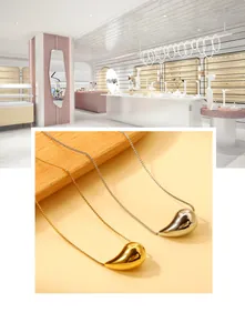 Macro view of water drop pendants in gold and silver finish with elegant box chains