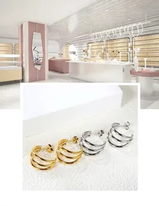 Detailed view of 18k gold and silver plated triple C-shape stud earrings with backings