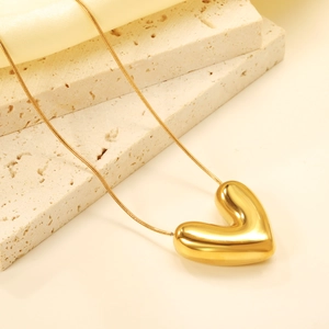 Minimalist 18K gold plated heart pendant necklace on an elegant travertine stone base