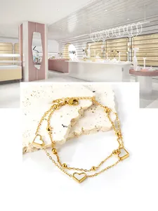 Détail du bracelet double couche en acier doré avec pendentifs cœurs en nacre blanche