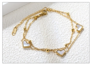 Détail d'un bracelet double couche en acier inoxydable avec cœurs en nacre blanche
