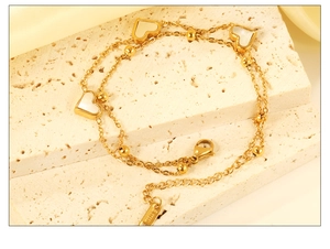 Détail du bracelet double couche en acier inoxydable avec breloques cœur en nacre