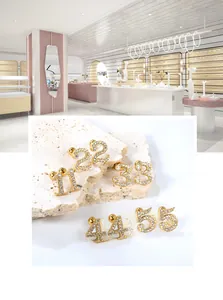 Detailed close-up of gold number stud earrings set 1-5 with sparkling zircon pavé