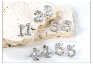 Detail of silver stainless steel number stud earrings with sparkling pavé crystals