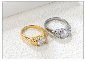 Detail view of gold and silver rings with oval zircon and textured metal band