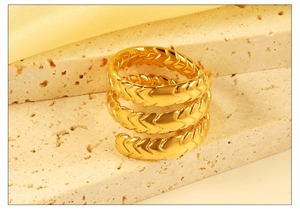 Macro view of multi-layer spiral 18K gold ring with detailed fishbone pattern texture