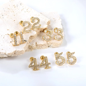 Golden stainless steel earring set with crystal numbers 1-5 on stone display